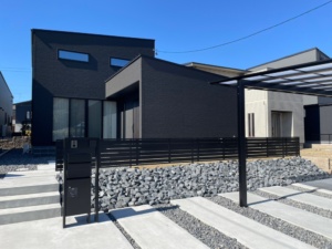 アイ工務店×モダンの外構エクステリアです。愛知県名古屋市緑区の新築外構工事の施工事例です。アイ工務店の注文住宅。シックなモダンスタイルでまとめ上げました。土間コンクリートにて駐車場を広く作成し、アルミ製品はブラックカラー。カーポート2台用はLIXILのネスカF、フェンスはフェンスABのYS3型をセレクトしています。機能門柱は三協アルミのフレムス。ミライエエクステリア　名古屋市名東区・天白区・昭和区・守山区・日進市・長久手市・瑞穂区エリア撮影 ＃おしゃれな外構　＃かっこいい外構
